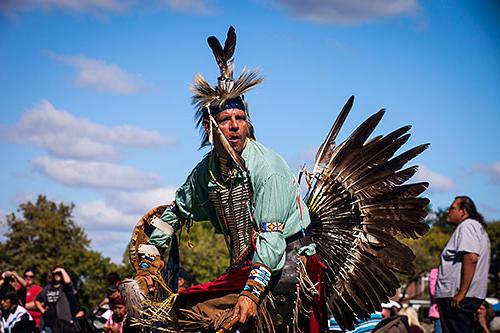 Traditional dancer in many brown feathers dancing