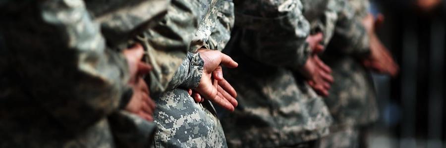 身着制服的军人们伸出双手准备接受OPE电子竞技官网颁发的学位和证书